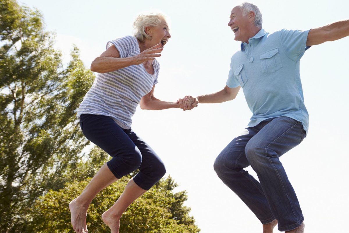 Older couple jumping on trampoline
