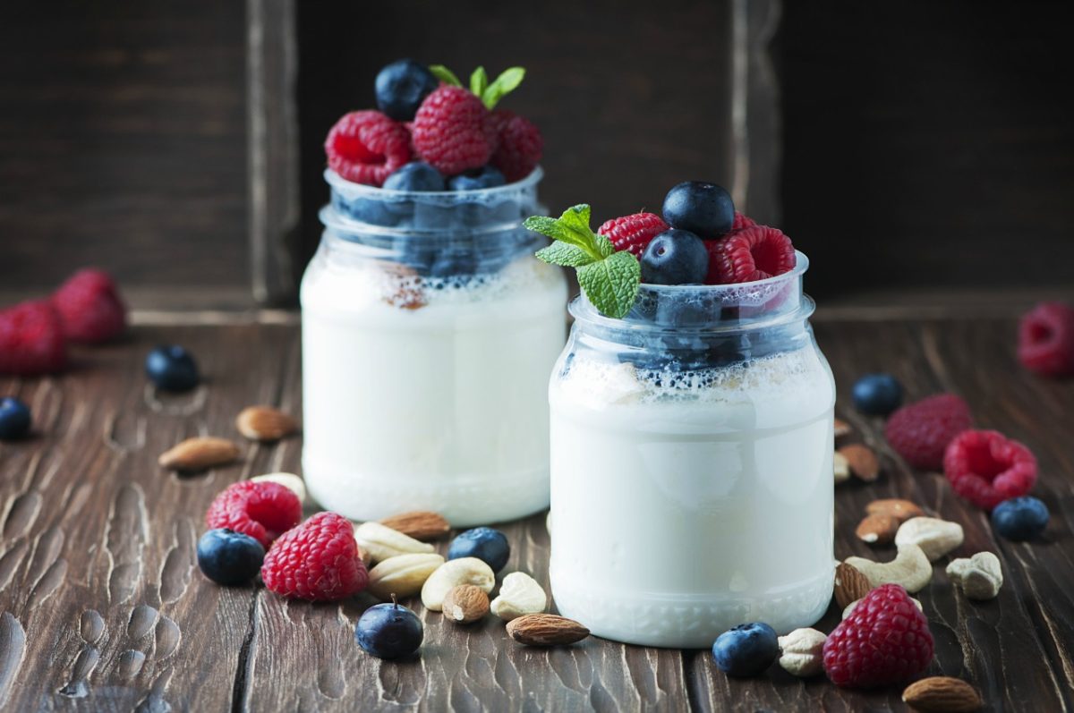Two mason jars with milk and topped with fruit